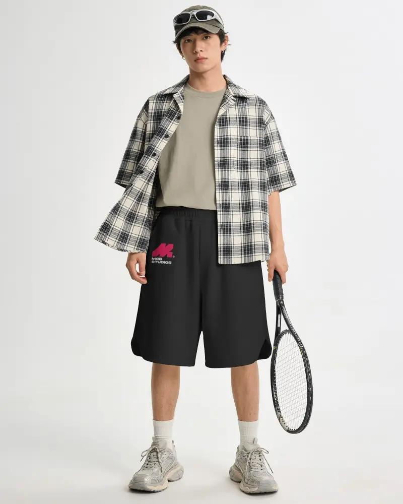 Tennis Inspired Shorts Mockup Male Model Holding Racket White Studio With Relaxed Streetwear Outfit