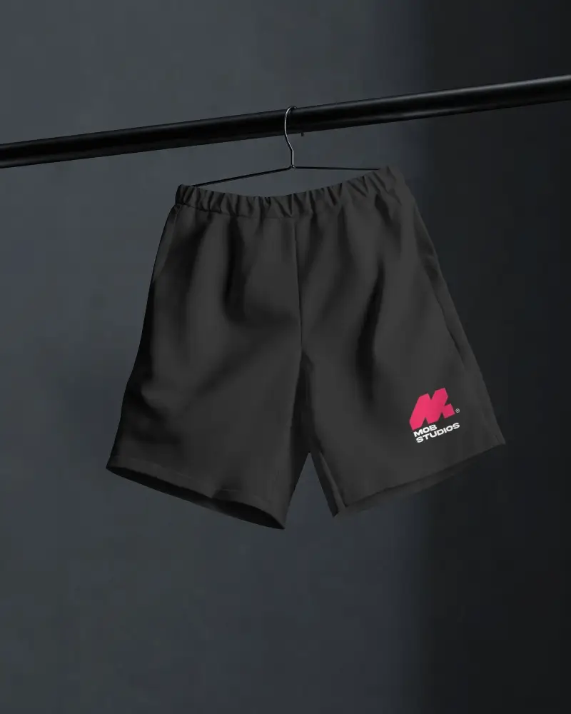 Hanging Shorts Mockup On Black Rod With Dark Studio Background And Realistic Fabric Folds