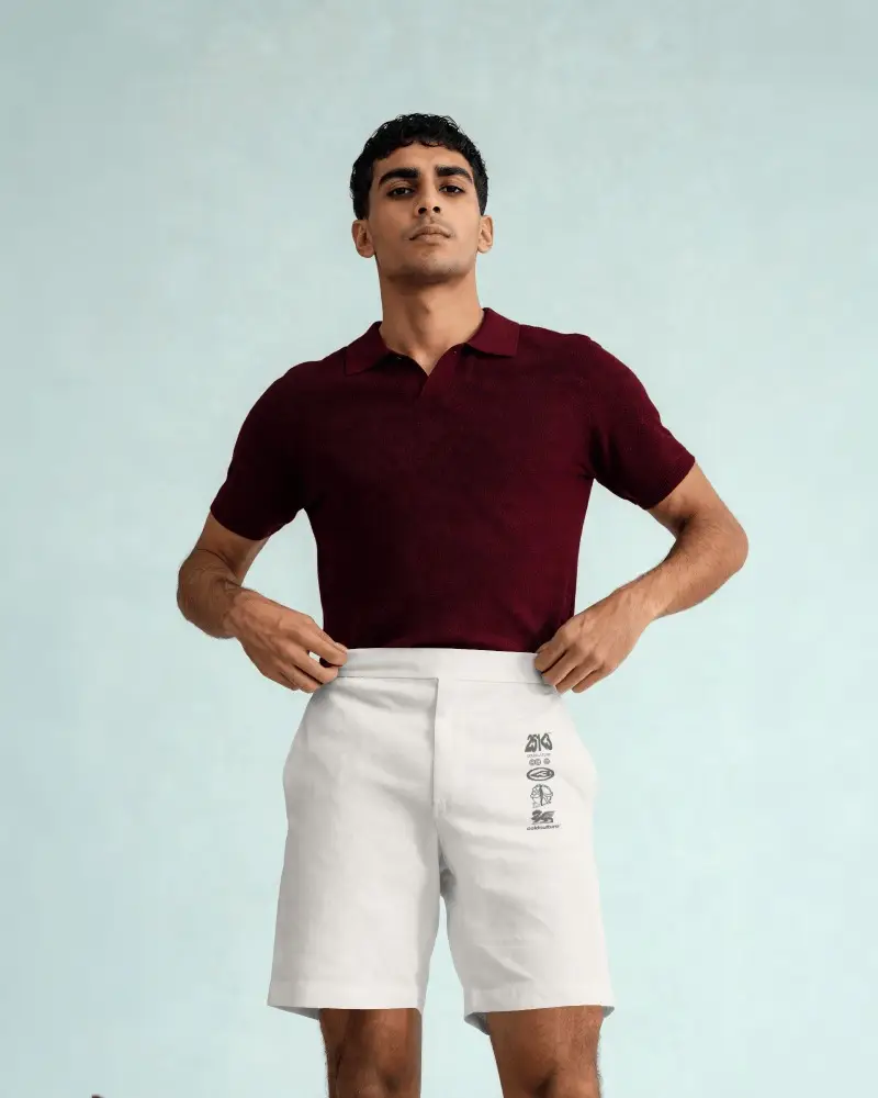 Mens Tailored Shorts Mockup With Front View Model Adjusting Waistband On Clean Studio Background