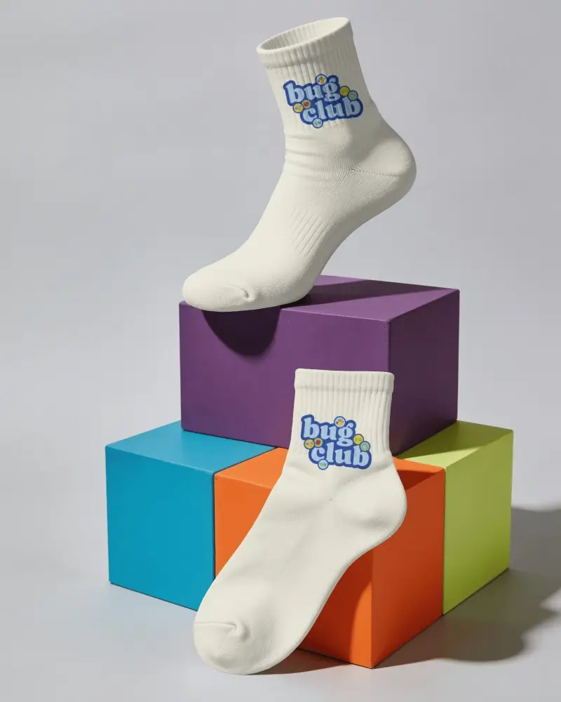 Creative Socks Mockup Featuring One Sock Hovering Above Blocks And Another Draped Over Front Edge