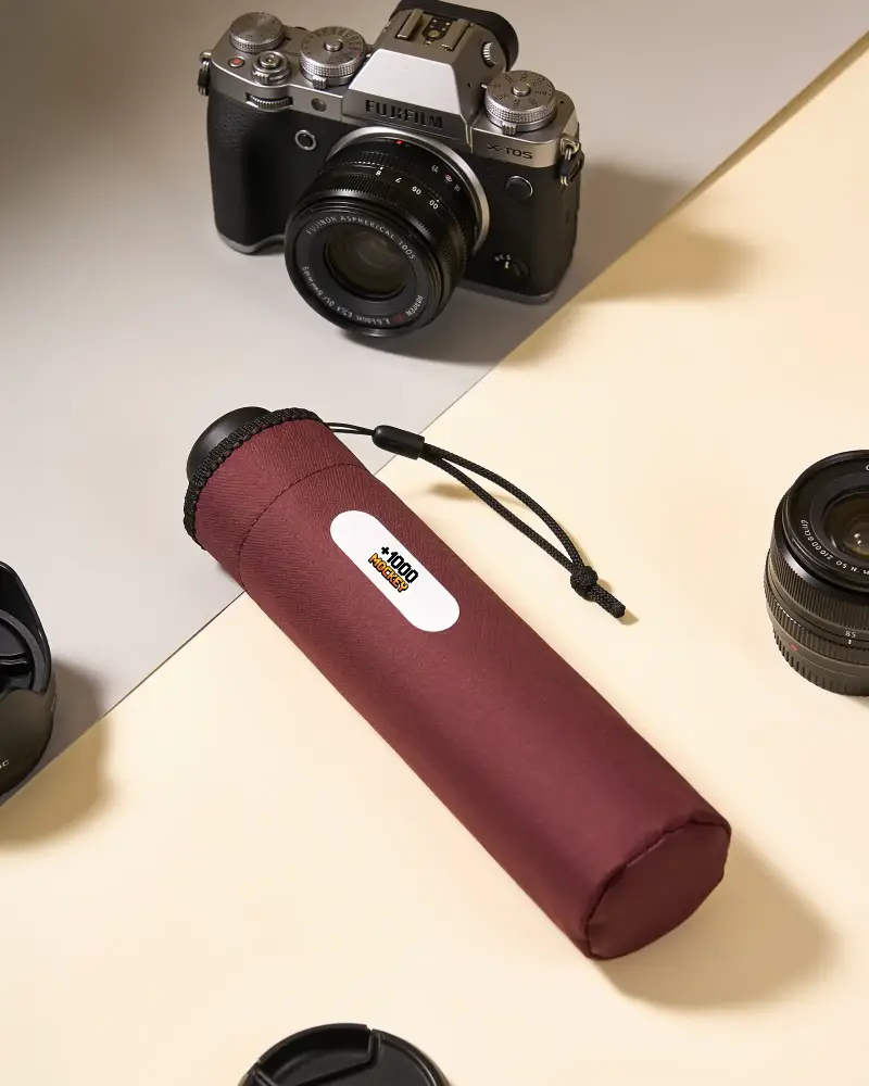 Blank Oval Sticker Mockup On Umbrella Sleeve With Camera Equipment Background