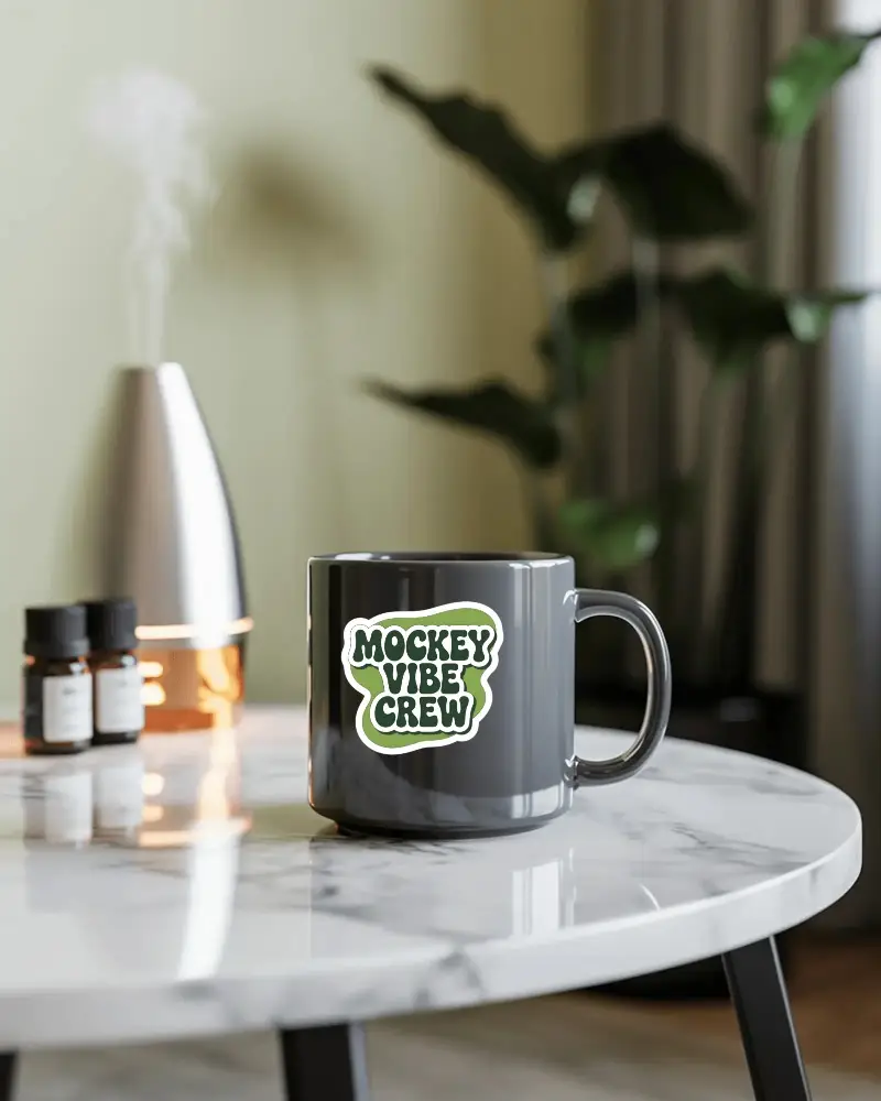 Sleek Ceramic Drinking Cup Placed On Round Marble Top Table In Cozy Living Room Sticker Mockup