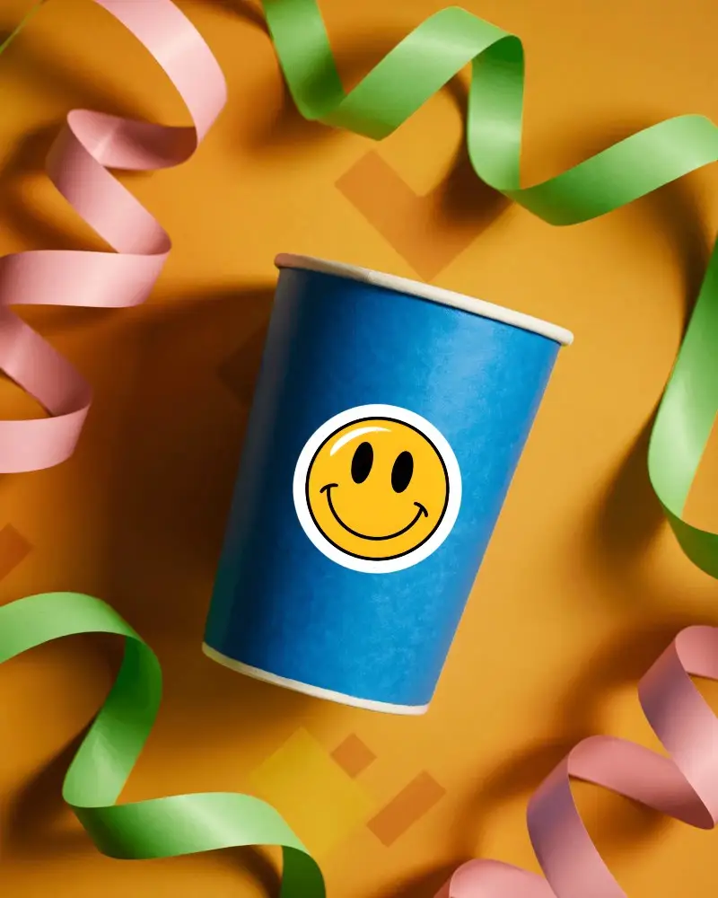 Blank Paper Cup Sticker Mockup Surrounded By Curled Streamers For Party Decors