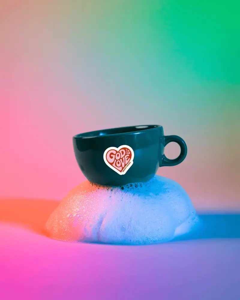 Sticker Mockups Ceramic Coffee Cup On Foam Pedestal With Vibrant Rainbow Gradient Studio Lighting