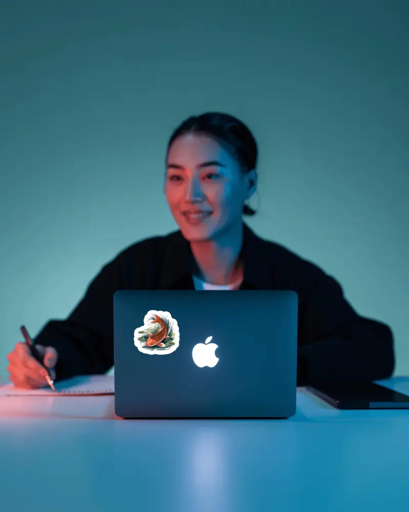 Sticker Mockups Woman Working On Laptop With Notebook In Cool Toned Modern Studio Lighting