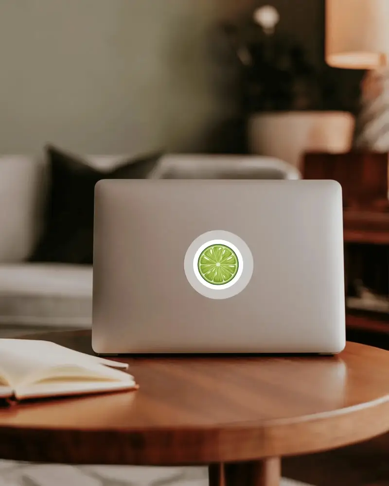 Sleek Laptop With Round Sticker Mockup On Backside Placed On Wooden Table In Cozy Room Setting