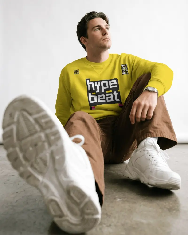 Low Angle Sweatshirt Mockup Male Model Sitting On Floor With White Sneakers In Minimal Studio