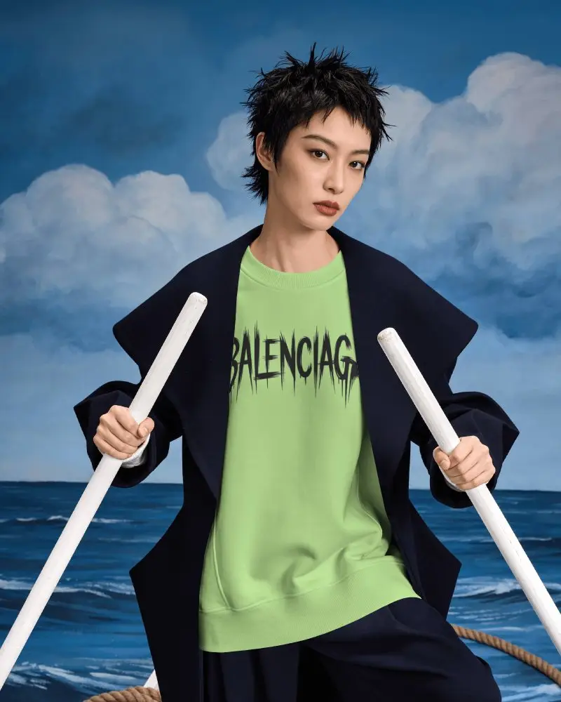Theatrical Sweatshirt Mockup Female Model Holding White Oars Against Painted Ocean Backdrop