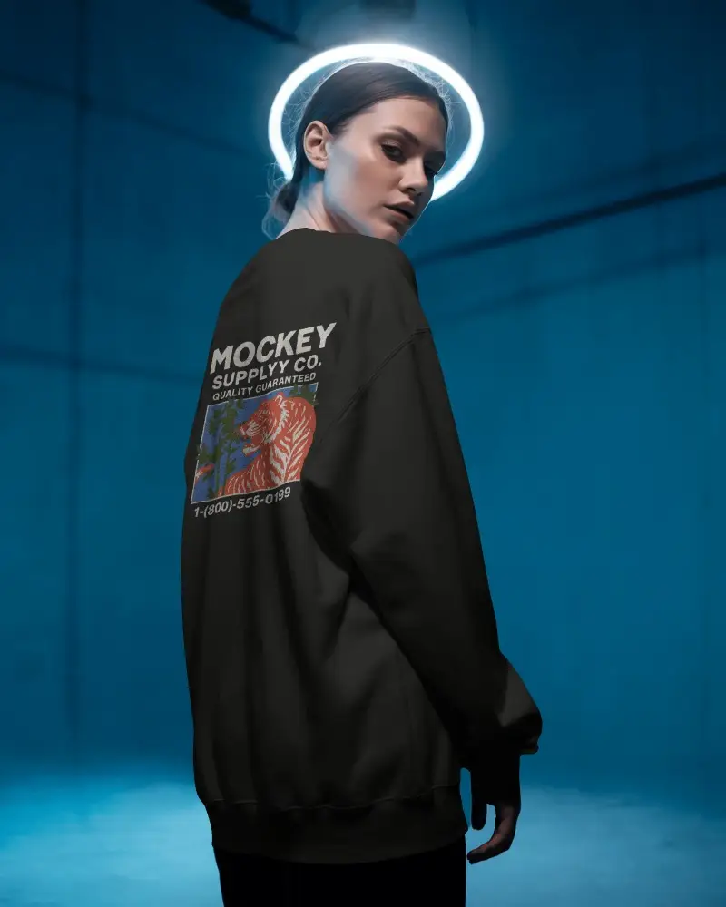 Moody Editorial Sweatshirt Mockup Woman In Side Pose Under Glowing Halo Against Studio Wall