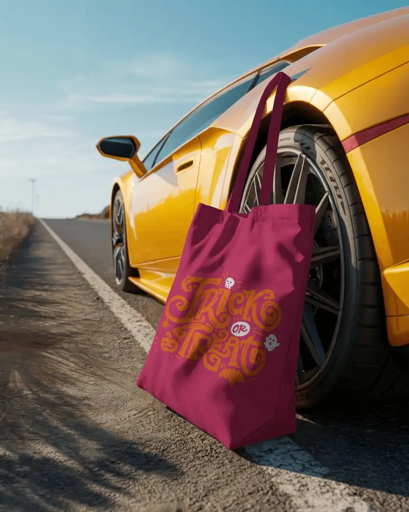 Roadside Lifestyle Tote Bag Mockup Resting On Ground Beside Yellow Sports Car Under Clear Blue Sky Travel Style