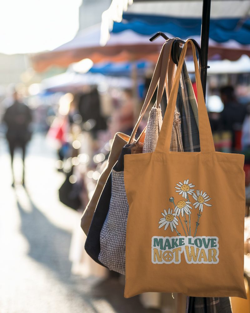 Sunlit Market Tote Bag Mockup White Canvas Bag Hanging On Rack With Assorted Bags Blurred Outdoor Background 0130