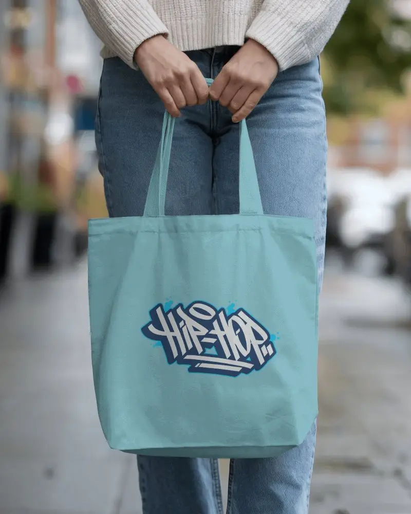 Street Style Totebag Mockup Front View Hands Holding Handles Outdoor Urban Setting Cozy Casual Outfit In Focus Blank Template With Placeholder Text