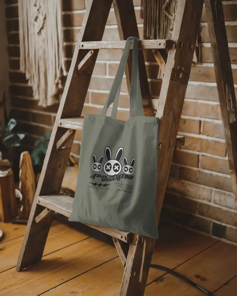 Home Decor Totebag Mockup Simple Tote Showcasing Design Zone In The Center Of A Curated Display On A Vintage Ladder With Brick Wall And Fringe Background Comfortable And Stylish Mood