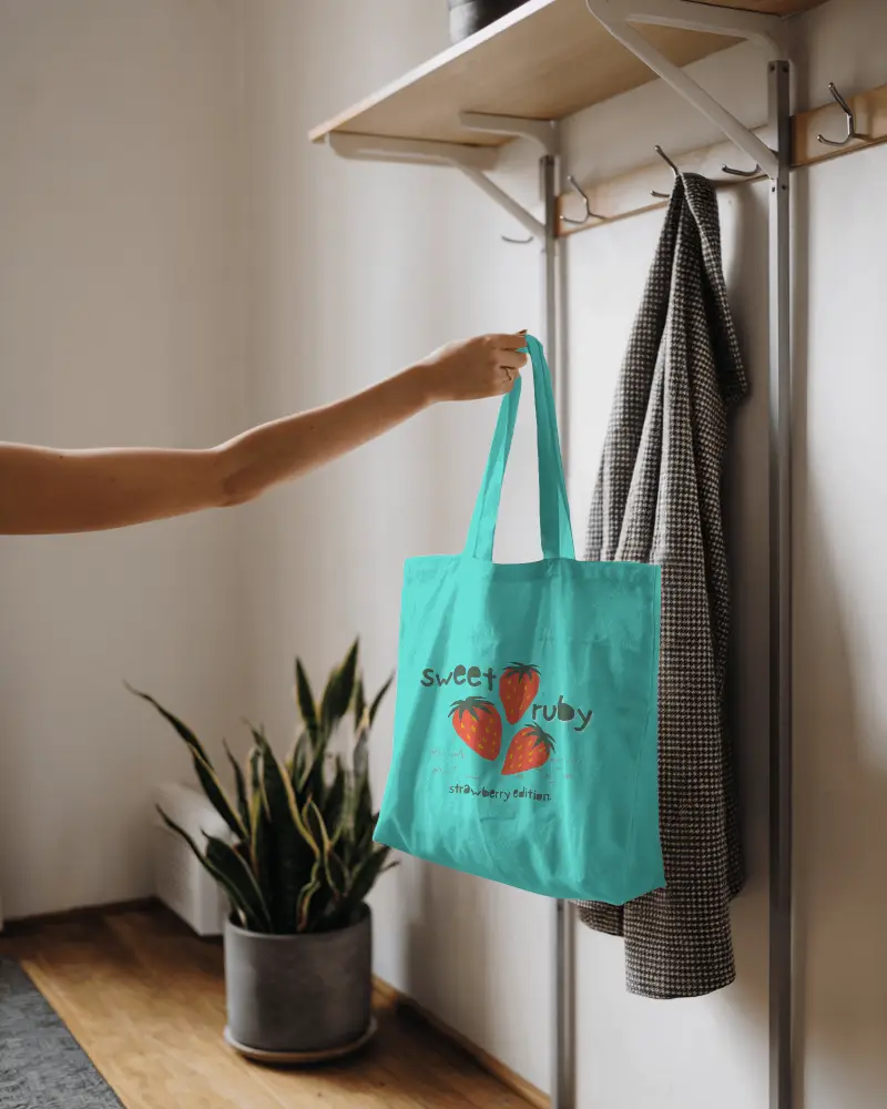 Minimalist Interior Tote Bag Mockup Held By Arm Near Coat Rack And Indoor Plant Clean Warm And Modern Home Setting