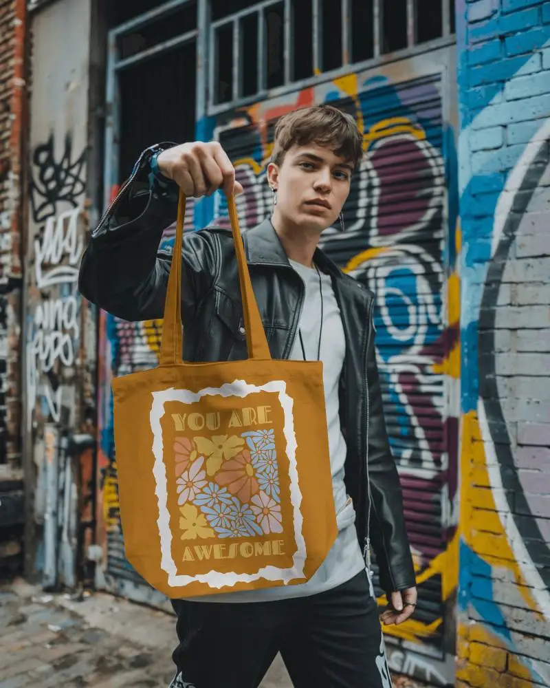 Gritty Urban Tote Bag Mockup Held By Model In Leather Jacket Against Colorful Graffiti Wall Edgy And Street Smart Style