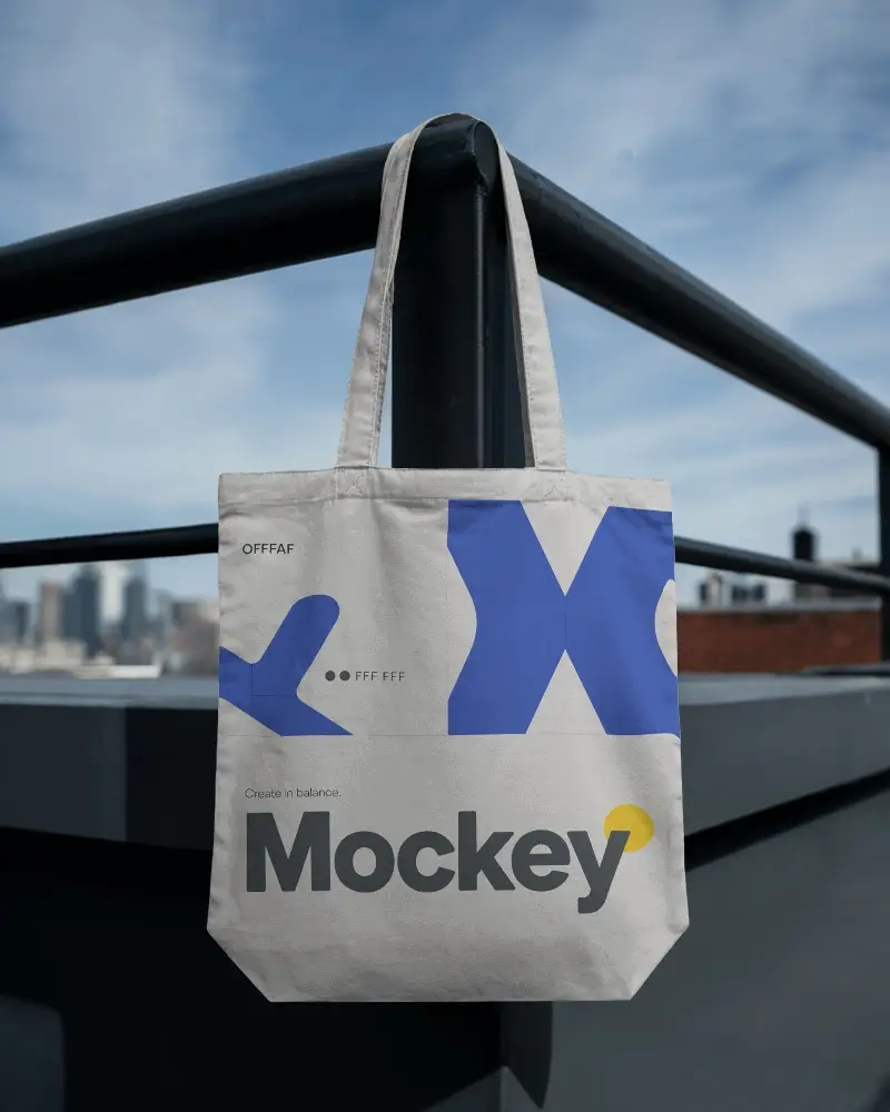 Rooftop Metal Railing Tote Bag Mockup Hanging Against Blue Sky Urban Cityscape Minimal Modern Style