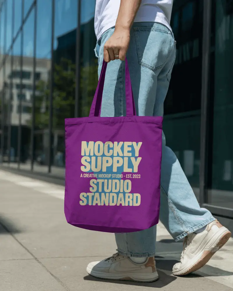 Casual Outdoor Tote Bag Mockup Male Model Walking In Denim Jeans Urban Street Daylight Scene