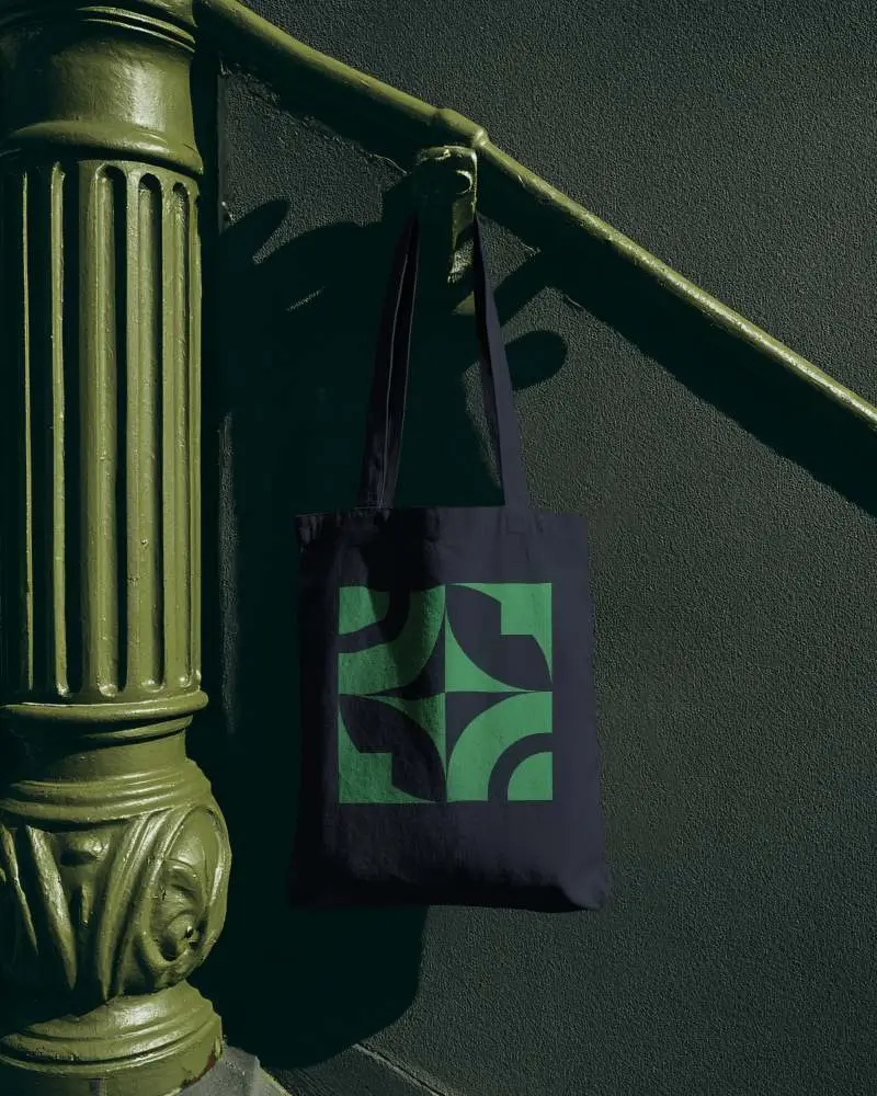 Ornate Column Totebag Mockup Hanging On Vintage Architectural Detail With Moody Light