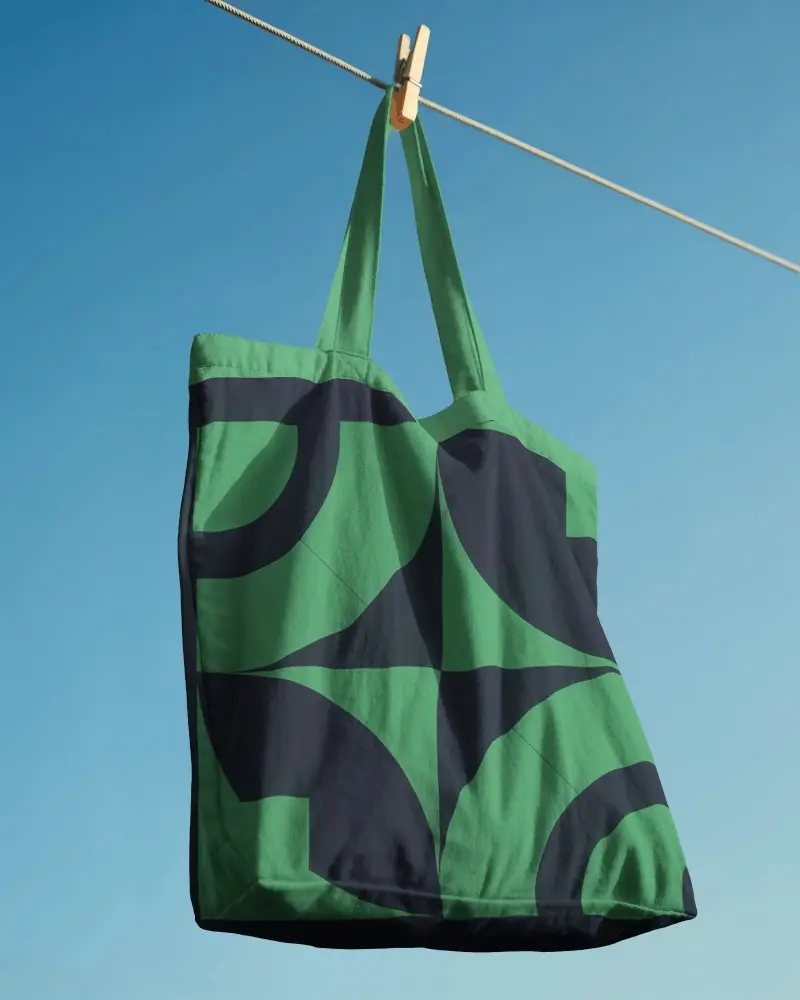 Eco Friendly Reusable Tote Bag Mockup Hanging On Clothespin Against Clear Sky Background