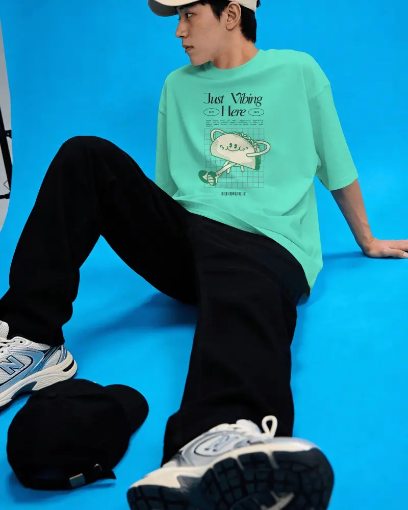Studio T Shirt Mockup On Model With Seated Pose And Vibrant Blue Background Studio Lighting