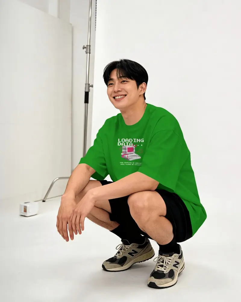 Studio Crouching T Shirt Mockup Male Model Relaxed Smile Clean White Backdrop Minimal Look