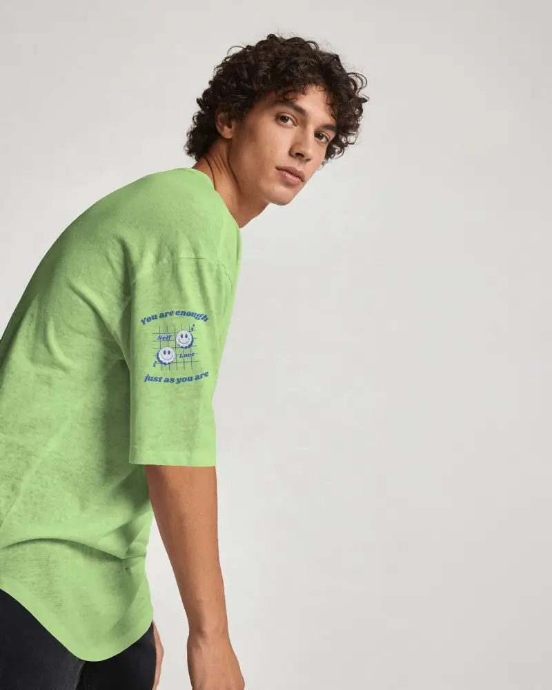 Modern Mens T Shirt Mockup On Model In Leaning Side Angle Pose With Simple Editorial Backdrop