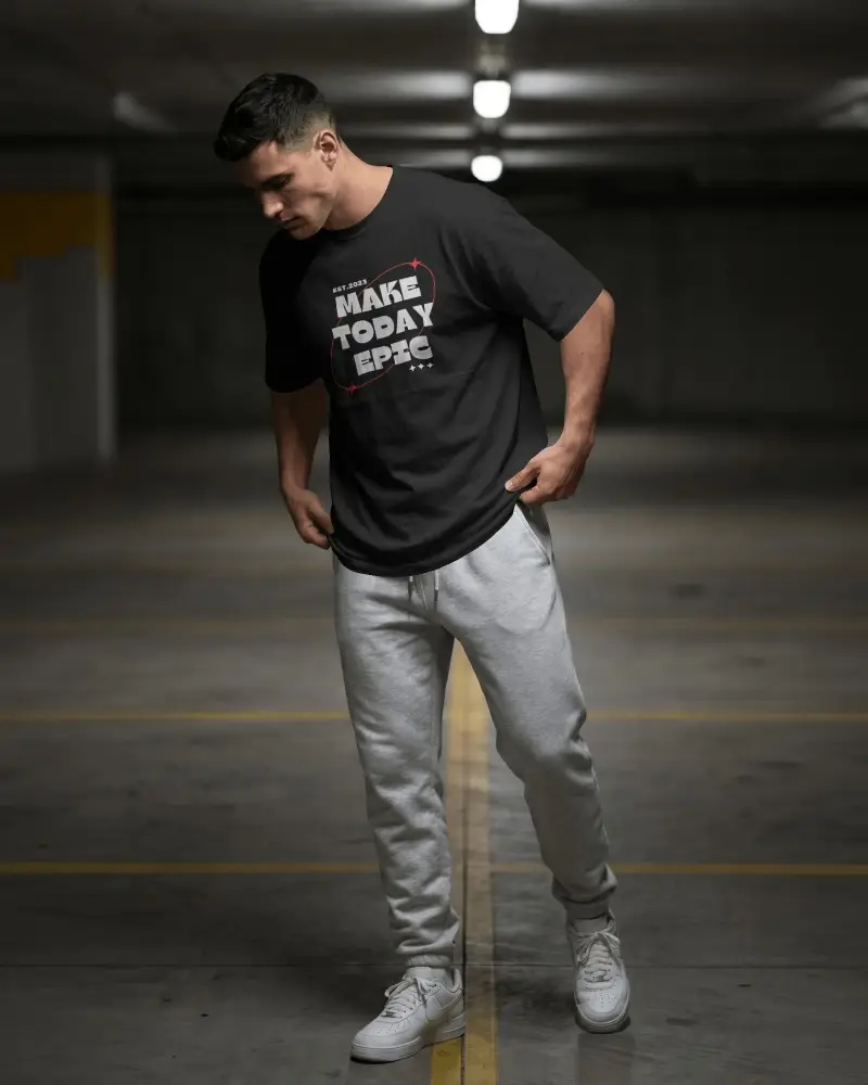 Underground Parking T Shirt Mockup Male Model Adjusting Hem With Moody Streetwear Attitude