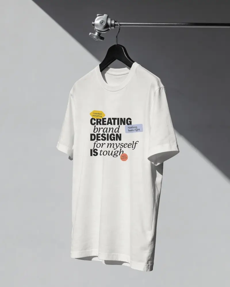 Hanging T Shirt Mockup On Black Hanger With Minimal Studio Shadow And Clean Apparel Focus