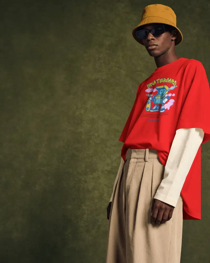 Layered Streetwear T Shirt Mockup Male Model With Bucket Hat And Sunglasses Against Textured Wall