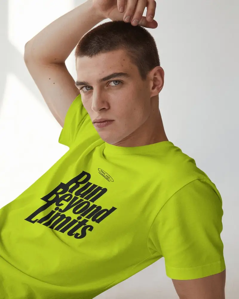 Reclining Mens T Shirt Mockup With Buzz Cut Model Raising One Arm Overhead In Sunlit Studio