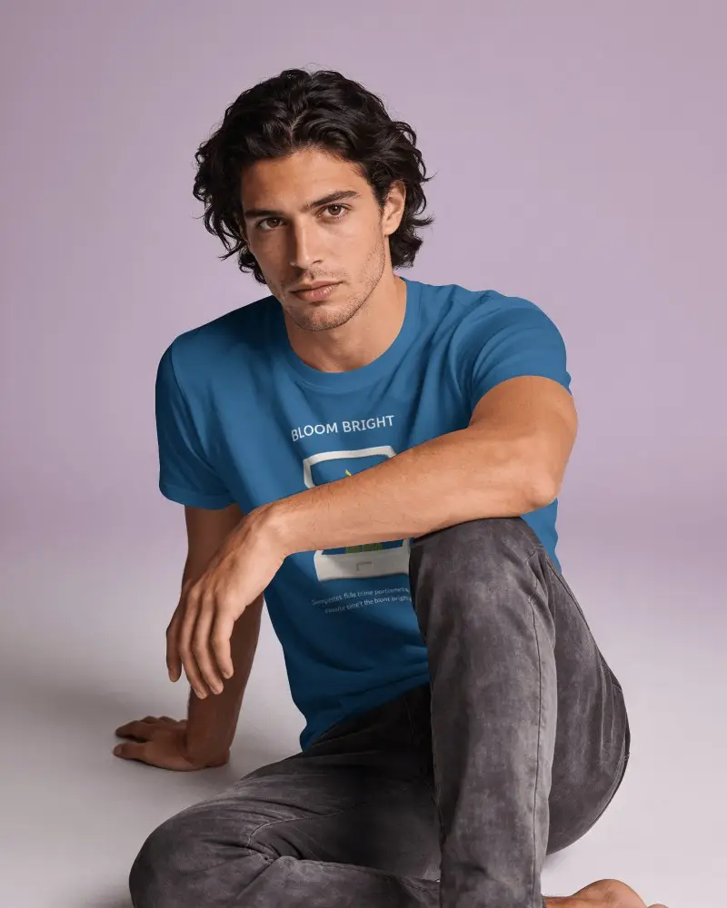 Seated Mens T Shirt Mockup With Curly Haired Model Resting Forearm On Raised Knee And Direct Gaze