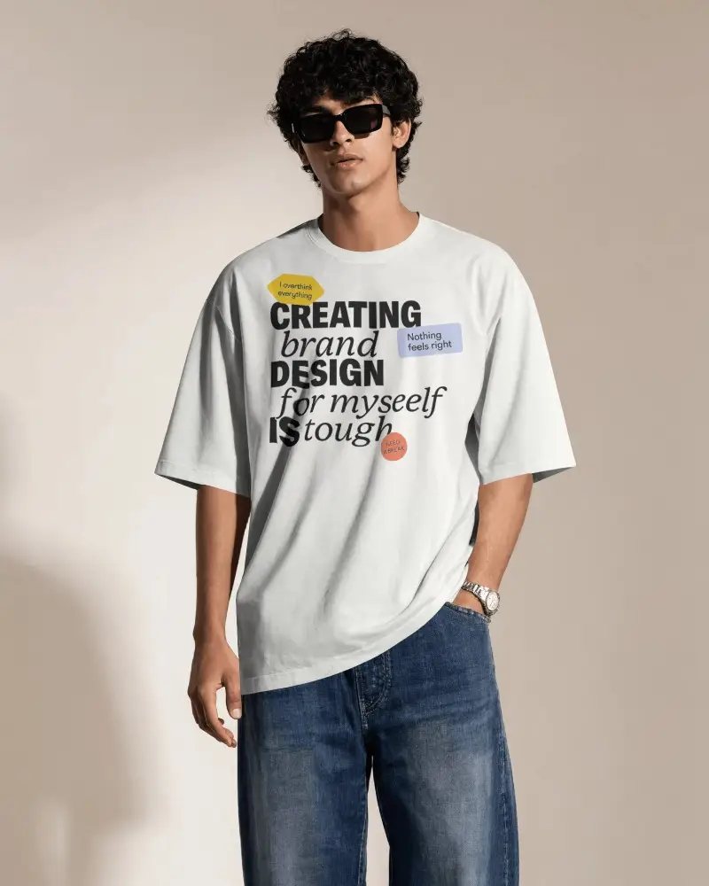 Oversized Mens T Shirt Mockup With Curly Haired Model Wearing Sunglasses And One Hand In Pocket