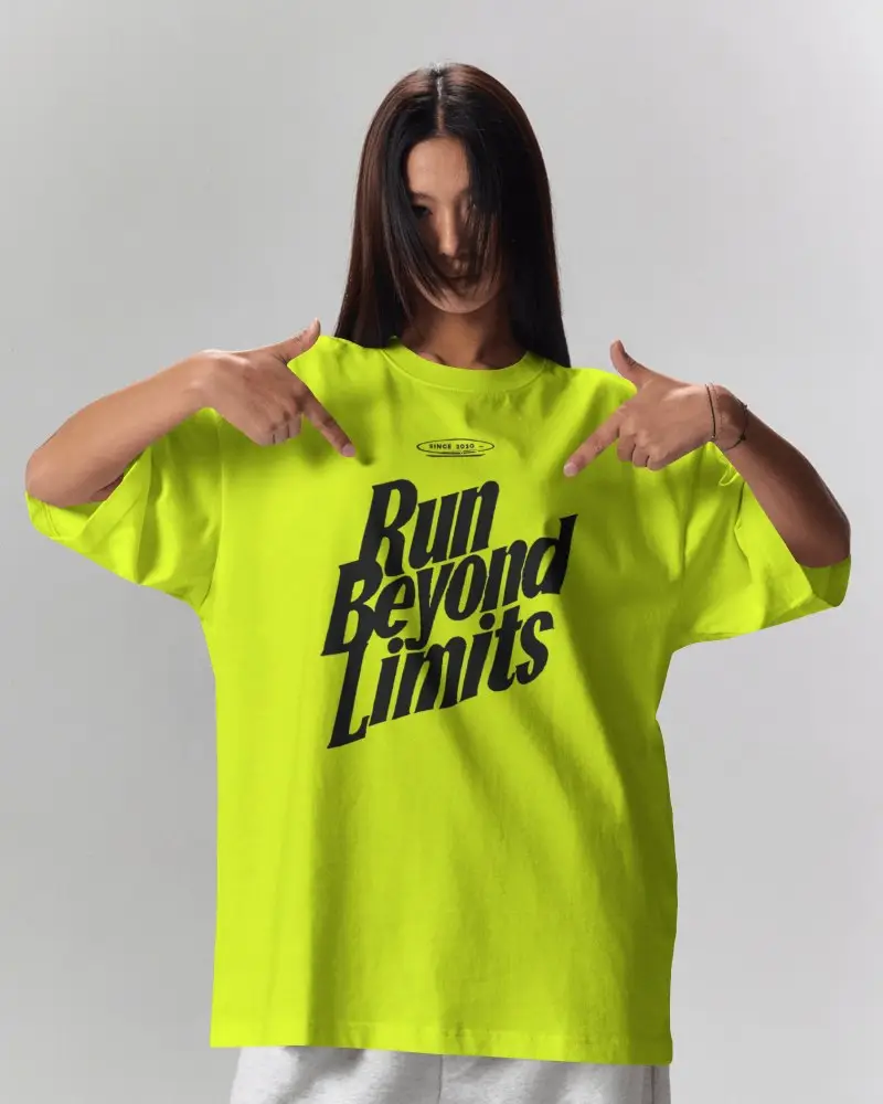 Studio T Shirt Mockup Female Model Pointing At Oversized Tee Both Hands Neutral Background