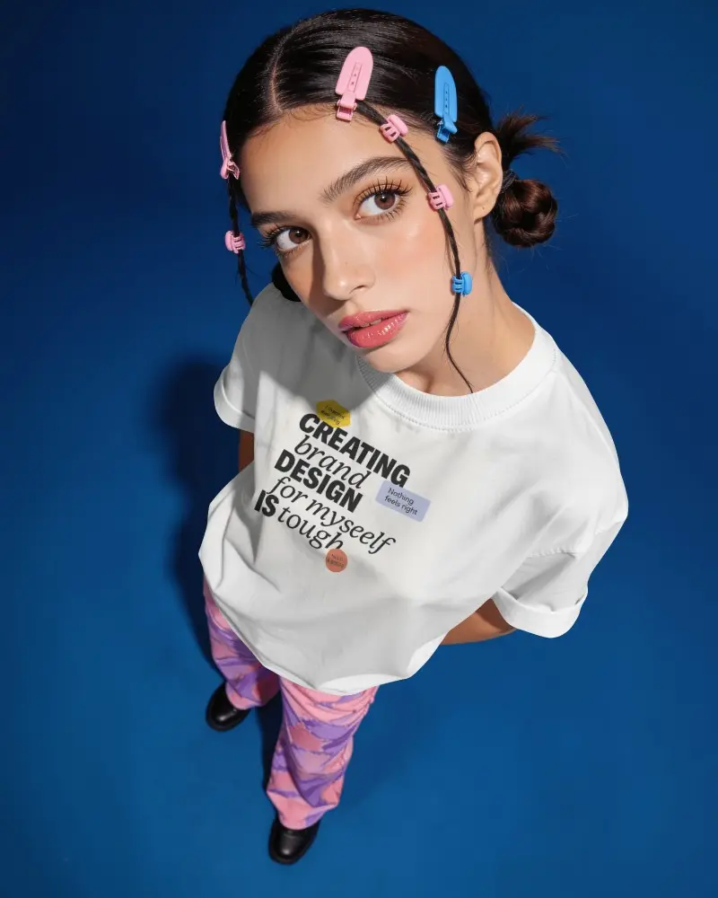 High Angle T Shirt Mockup Female Model Looking Up Oversized Tee Colorful Hair Clips Blue Background