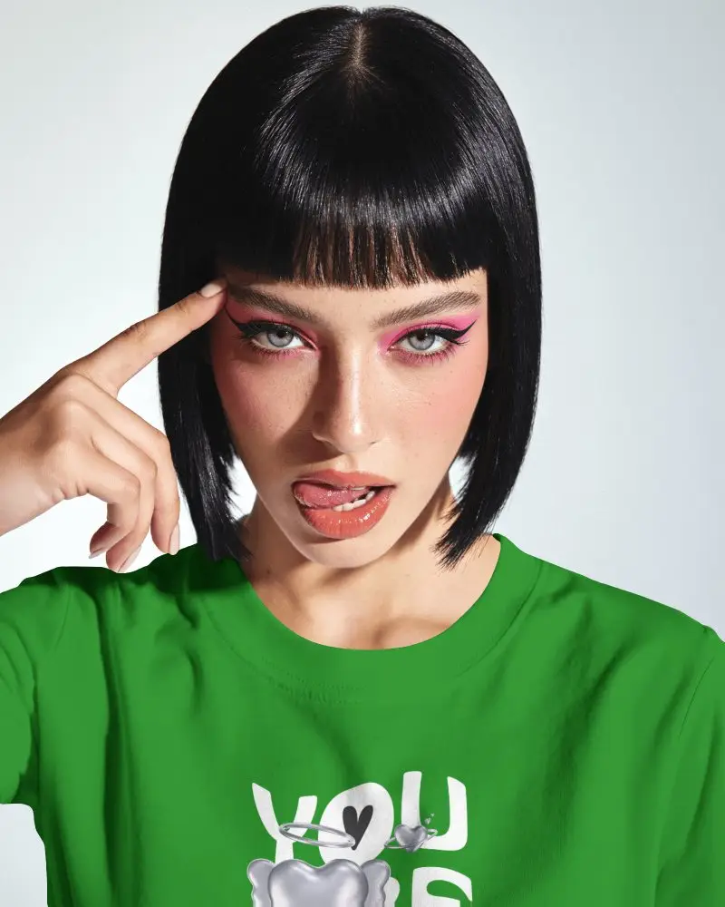 Close Up T Shirt Mockup Female Model Bob Haircut Bangs Pink Makeup Pointing To Temple Studio