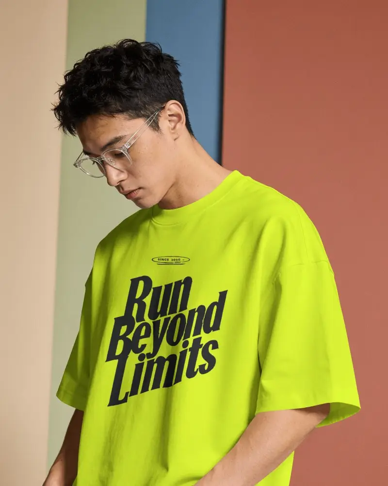 Oversized T Shirt Mockup Male Model Wearing Glasses Against Color Blocked Studio Background