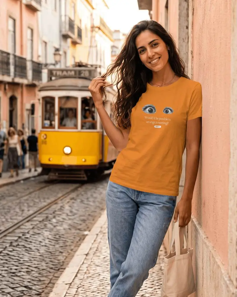 Lisbon Street T Shirt Mockup Smiling Female Model Leaning Against Cobblestone Wall With Yellow Tram