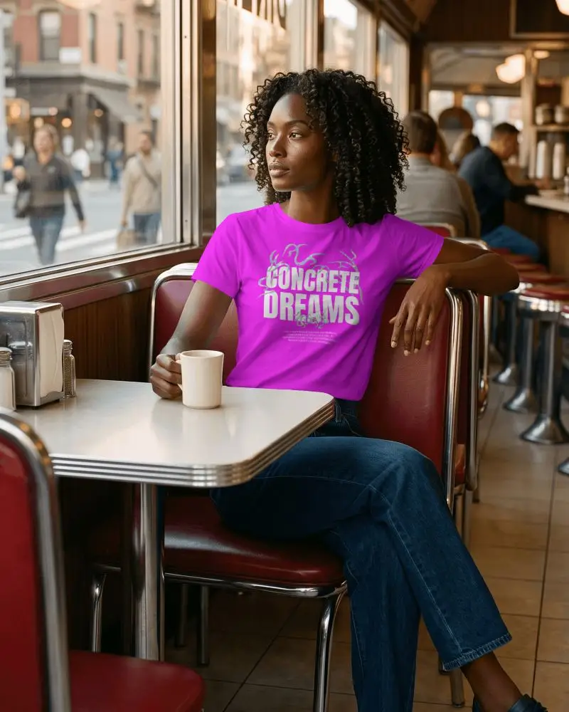 Vintage Diner T Shirt Mockup Curly Haired Female Model Sitting In Retro Booth With Coffee Cup