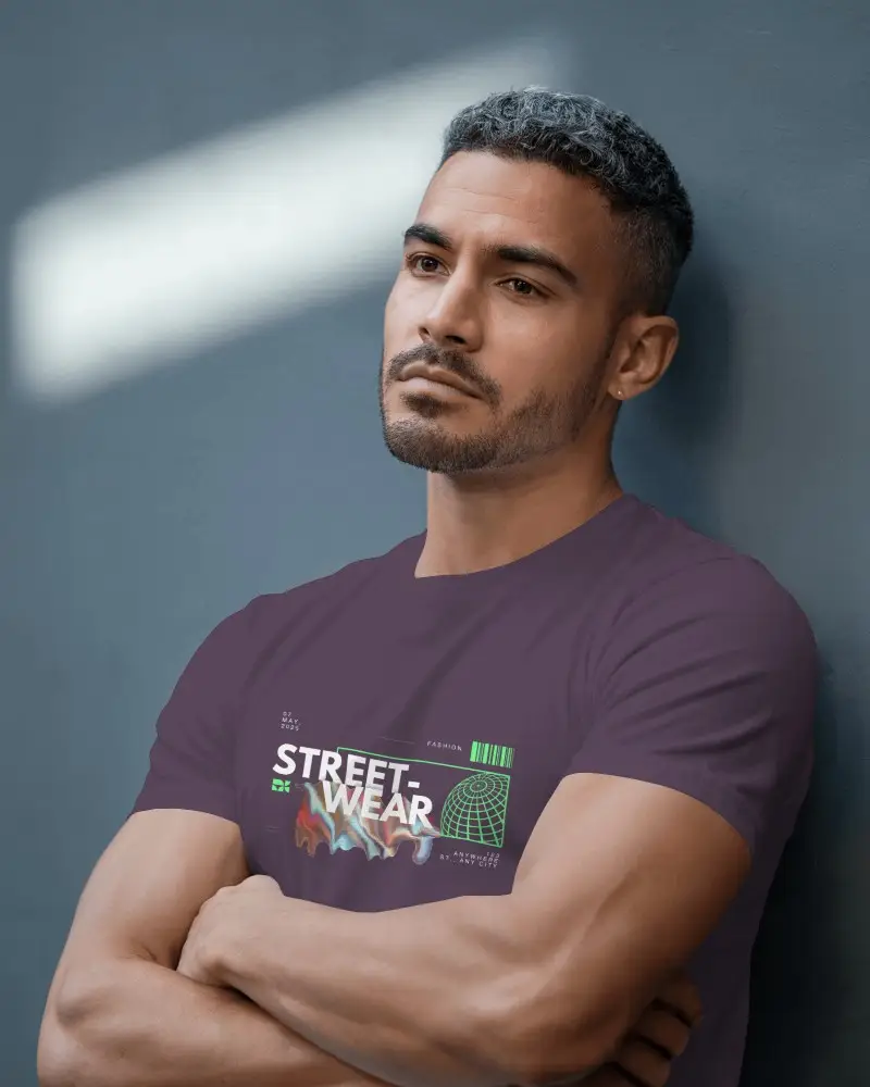 Modern Studio T Shirt Mockup Male Model Leaning Against Wall In Natural Lighting Calm Expression