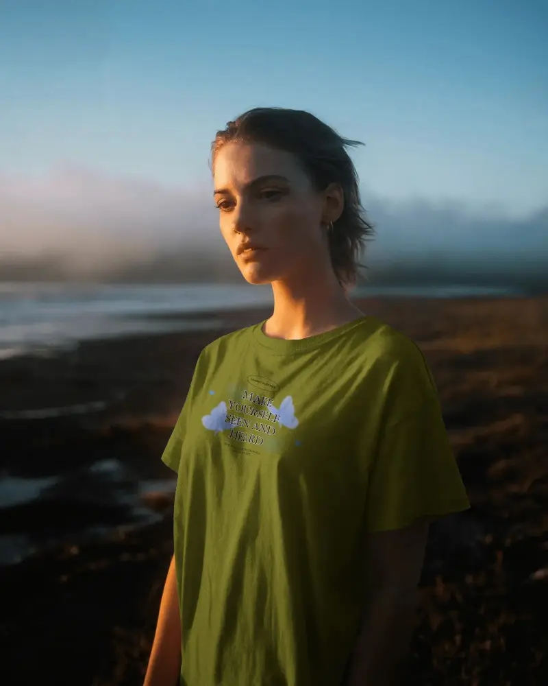 Golden Hour Beach T Shirt Mockup Female Model Gazing Serenely Sunset Lighting Tranquil Atmosphere