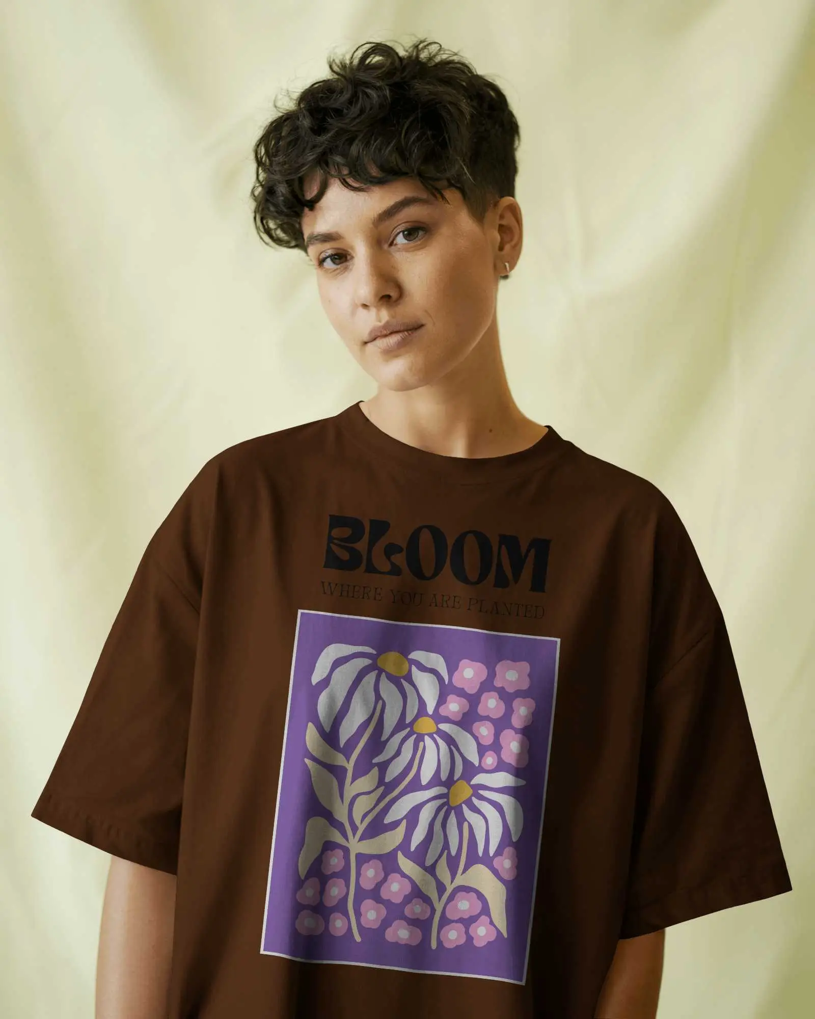 Neutral Backdrop T Shirt Mockup Female Model With Short Curly Hair Wearing Oversized Grey Tee Minimalist Studio Look