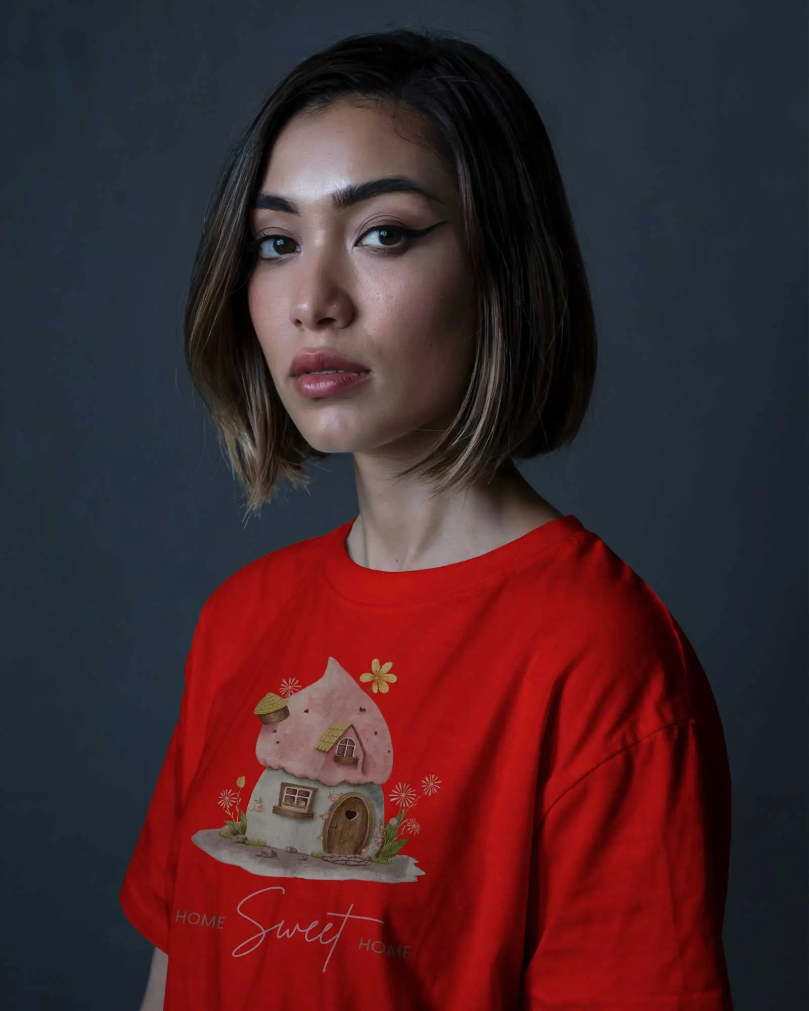 Studio T Shirt Mockup Female Model With Bob Hair In Beige Tee Against Dark Moody Background Confident Expression