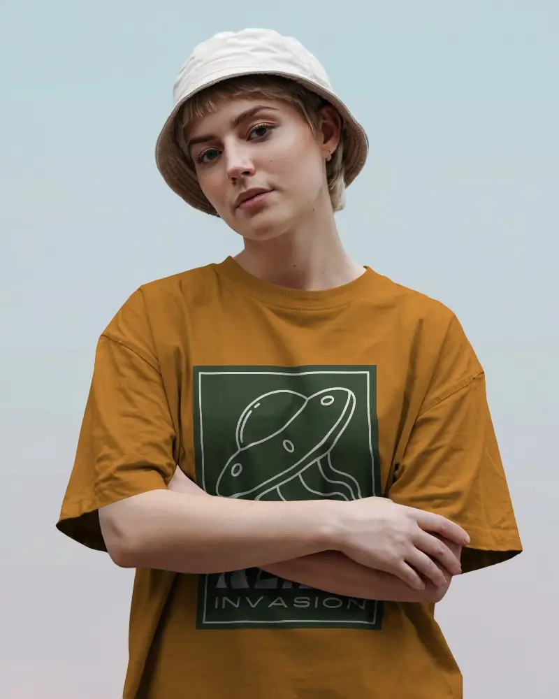 Outdoor T Shirt Mockup Female Model In Grey Tee And Beige Bucket Hat Posing With Folded Arms Under Soft Sky Gradient