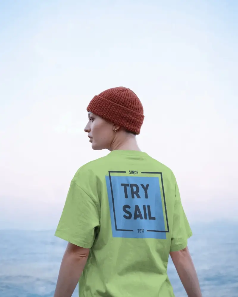 Ocean View T Shirt Back Facing Model In Red Beanie Under Soft Sky Gradient