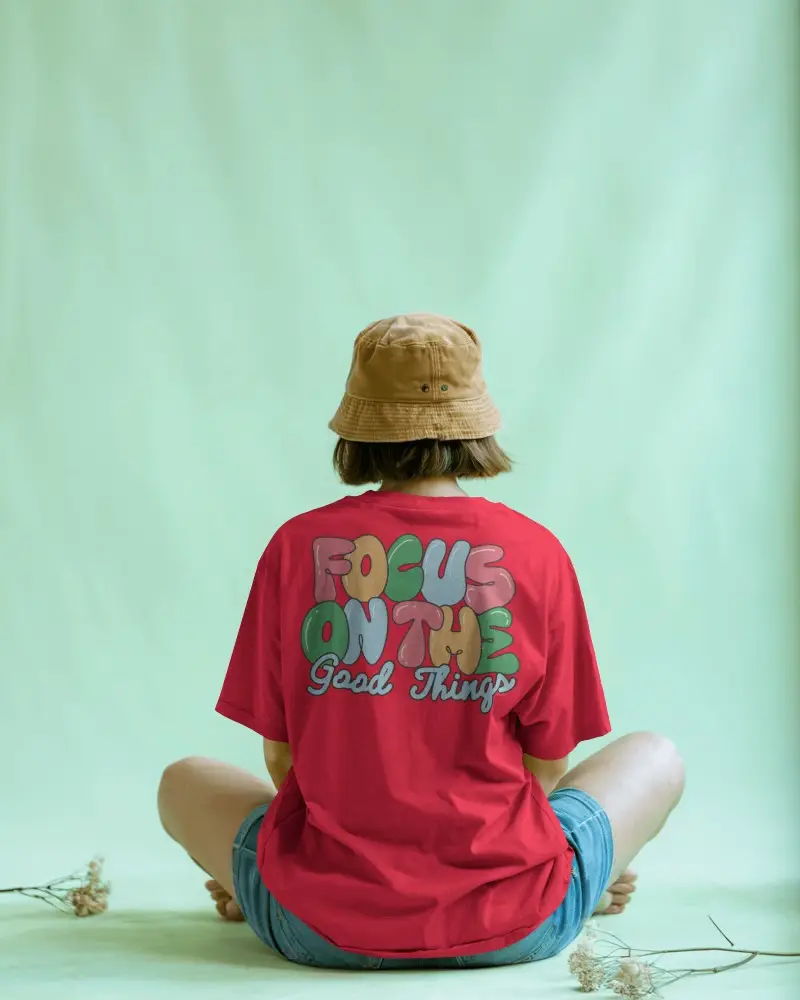 Minimal Studio T Shirt Mockup Back View Female Model Sitting On Floor With Beige Bucket Hat And Calm Aura