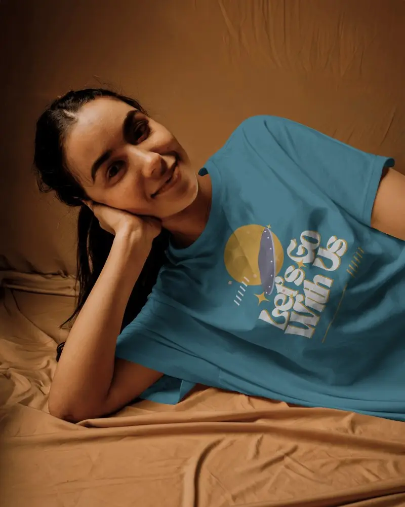 Relaxed Pose T Shirt Mockup Female Model Lying On Brown Fabric With Natural Light