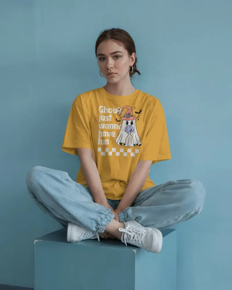 Minimalist Studio T Shirt Mockup Female Model Sitting Cross Legged In Blue Toned Space