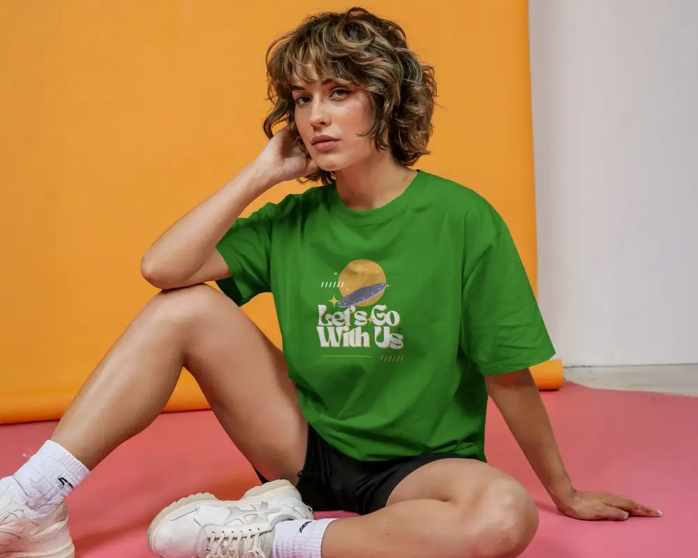 Sporty Studio Tshirt Mockup Female Model Sitting On Pink Floor With Orange Backdrop