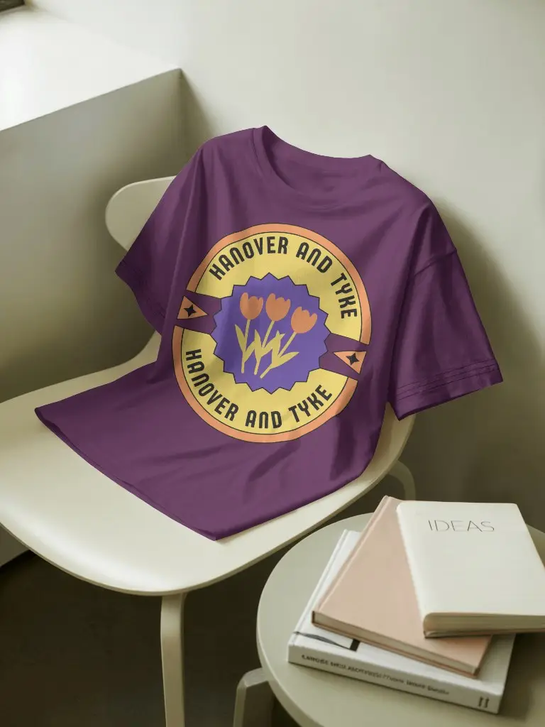 Minimalist Tshirt Mockup Draped On Ivory Chair Next To Books And Round Table In Clean Creative Workspace