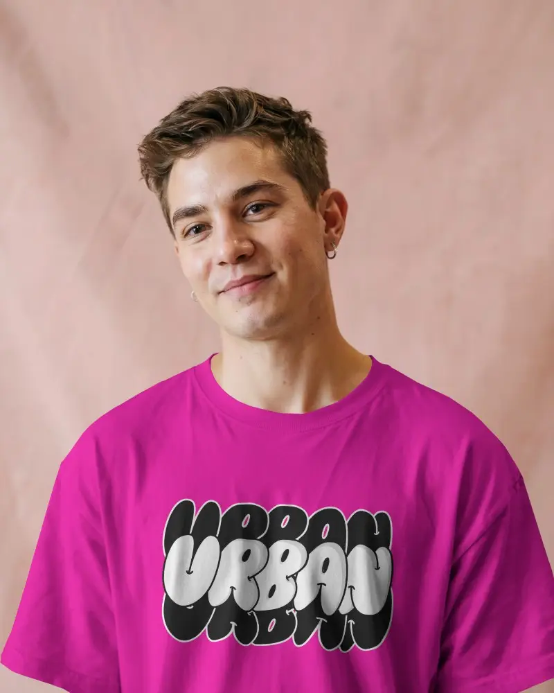 Studio Soft Light T Shirt Mockup Male Model Smiling With Pink Textured Backdrop Casual And Friendly Vibe